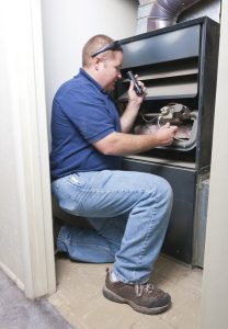 technician working on the inside of a furnace