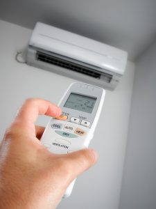 hand-holding-remote-turning-on-ductless-air-handler