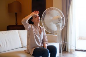 woman-sitting-in-front-of-fan-trying-to-cool-off