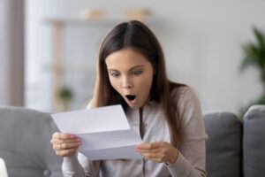 woman-looking-at-bill-with-shocked-expression-on-face